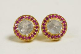 A pair of silver gilt earrings set with an uncut diamond encircled by rubies