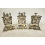 A pair of C19th table top cigar lighters of ornate, square plinth style, 4½" high, and another A/F