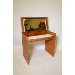 A 1960s blond teak compact dressing table by Stag, the top opening to reveal a mirror and storage