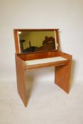 A 1960s blond teak compact dressing table by Stag, the top opening to reveal a mirror and storage