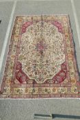 A vintage cream ground Persian Tabriz carpet, with wear and repairs, 81" x 113"