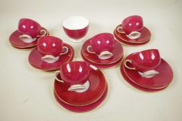 A mottled, red glazed porcelain tea service with gilt highlights, 19 pieces