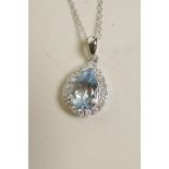 An 18ct white gold pendant necklace set with a pear shaped aquamarine encircled by diamonds,