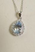 An 18ct white gold pendant necklace set with a pear shaped aquamarine encircled by diamonds,