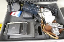 An aluminium flight case containing four cameras, a Halina 35m, Canon Eos 500 35mm, Kodak Junior