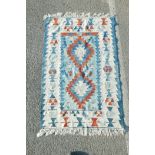 A Swedish blue ground rug decorated with geometric twin medallion design, 41" x 62"