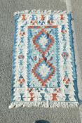 A Swedish blue ground rug decorated with geometric twin medallion design, 41" x 62"