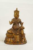 A Sino Tibetan bronze figure of an emperor seated on a throne set with semi precious stones, with