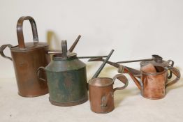 A vintage copper watering can, 17" high, two others smaller, a copper oil can and a toleware