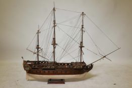 A scratch built wooden model of a three masted 62 gun warship complete with brass cannon, hull to