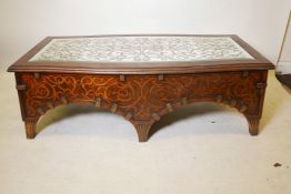 An American walnut coffee table with an eglomise shaped top, scrolling decoration and ribbed