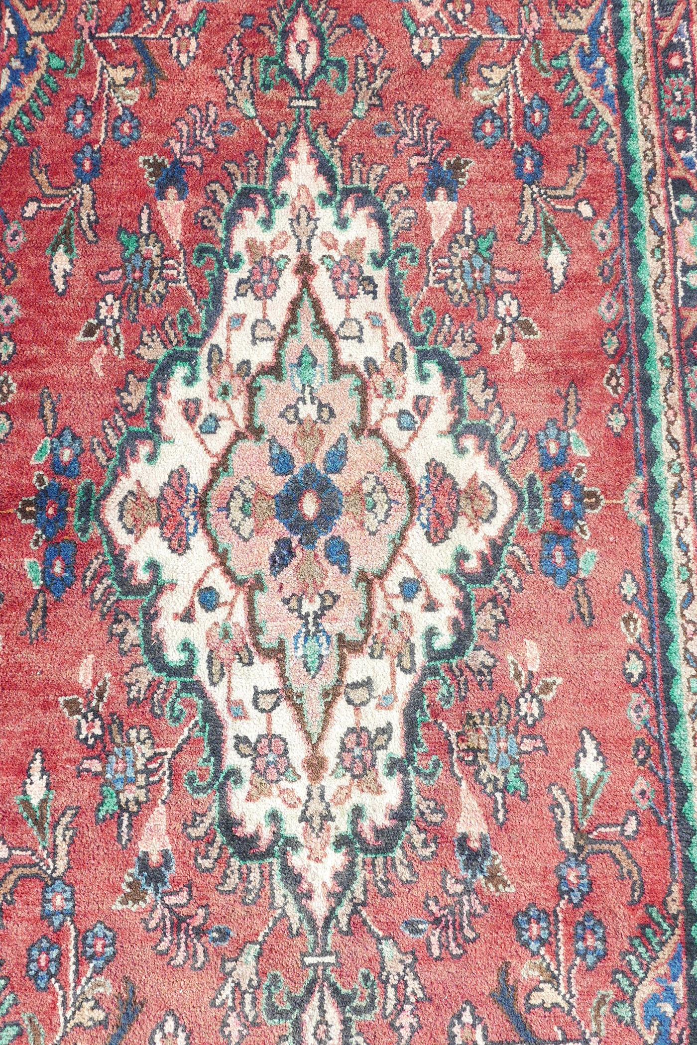 A full pile Sarouk runner with a traditional design on a red ground, 46" x 123" - Image 2 of 4