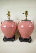 A pair of Oriental style pink glazed porcelain table lamps in the form of bulbous two handled