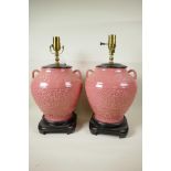 A pair of Oriental style pink glazed porcelain table lamps in the form of bulbous two handled