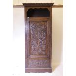 A C19th carved oak hall cupboard with single door over drawer, 35" x 18" x 80"