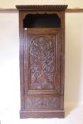 A C19th carved oak hall cupboard with single door over drawer, 35" x 18" x 80"