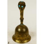 A small Oriental brass table bell with engraved floral decoration and inset with turquoise beads, 4"