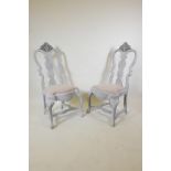 A pair of early C20th Gustavian style painted and distressed chairs, with carved details, 45" high