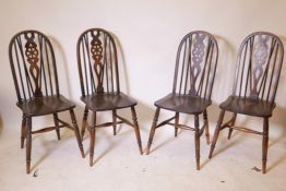 A set of four wheel back chairs with elm seats