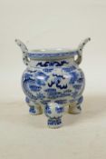 A Chinese blue and white porcelain two handled censer on tripod feet, decorated with dragons chasing