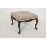 A C19th carved walnut stool of serpentine shape on cabriole supports with tapestry upholstery, 16"