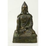 A Sino-Tibetan bronze figure of a Buddhist monk seated in meditation, 9" high