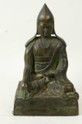 A Sino-Tibetan bronze figure of a Buddhist monk seated in meditation, 9" high