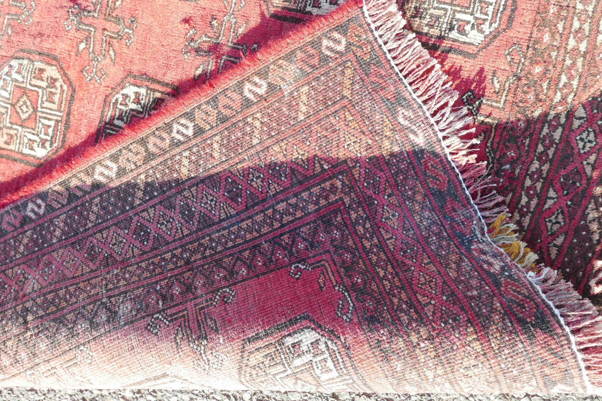 A washed red ground Turkmen carpet with a Bokhara design, repairs, 56" x 90" - Image 6 of 6