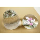 A pink and white florally decorated paperweight, signed, 3" diameter, together with a faceted