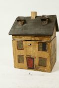 A novelty painted wooden tea caddy in the form of a house with gabled roof, 8½" high x 6¼" wide