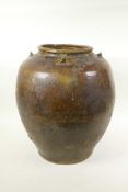 An Oriental treacle glazed pottery jar with four handles, 15" high, A/F