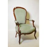 A Victorian carved mahogany spoonback open armchair with upholstered seat and back on shaped