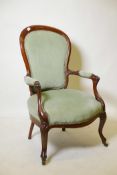 A Victorian carved mahogany spoonback open armchair with upholstered seat and back on shaped