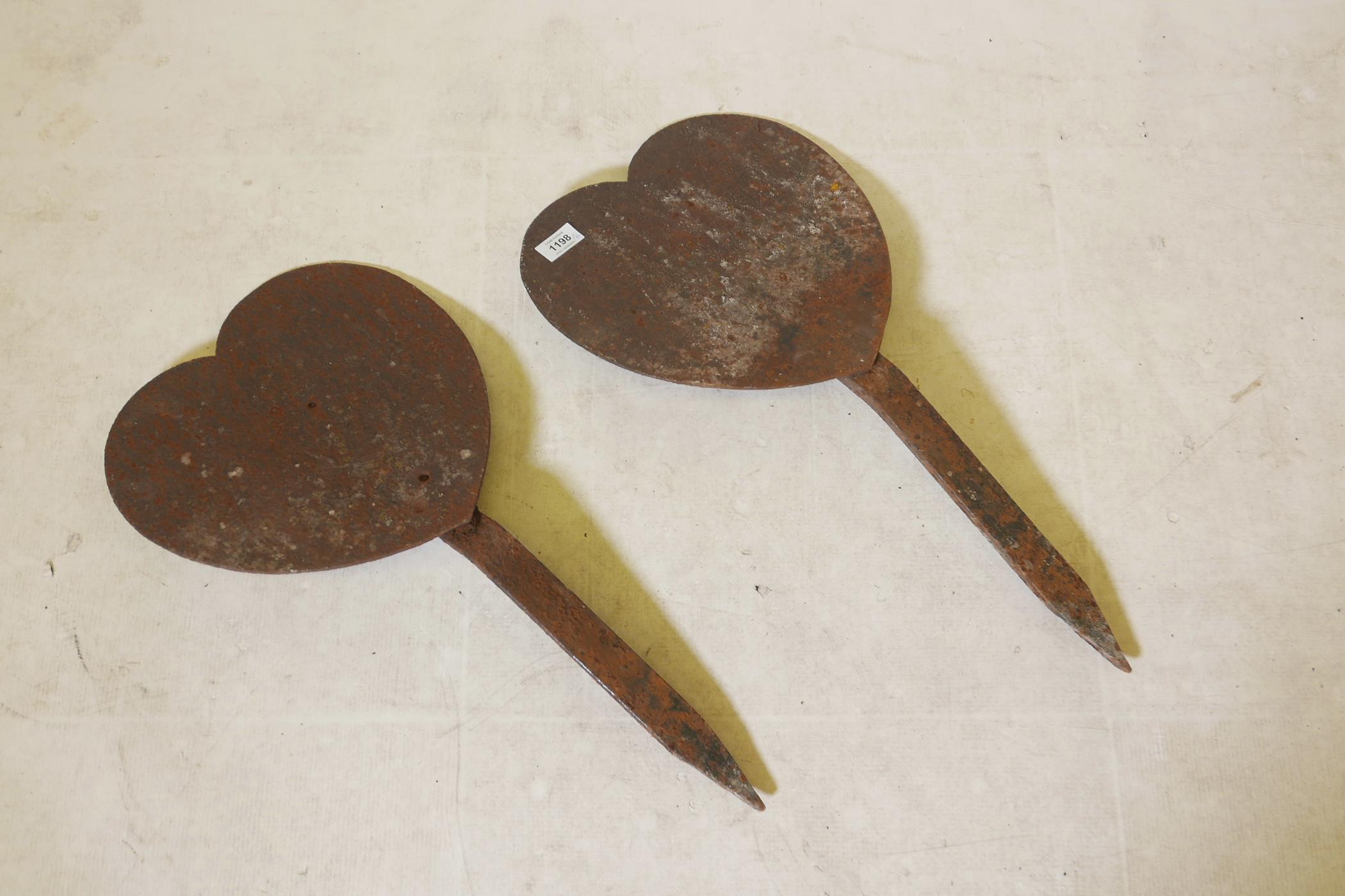 A pair of antique cast iron, heart shaped markers, 24" high