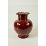 A Chinese flambe glazed pottery vase of ribbed form with a rolled rim, 9½" high