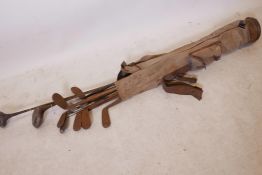 A quantity of vintage golf clubs with hickory and metal shafts, in a bag