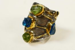 A sterling silver contemporary gemstone ring, set with rough uncut blue tourmaline and peridot,