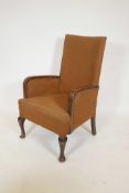 A 1920s high back armchair, raised on cabriole supports
