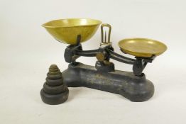 A Libra Co cast iron and brass kitchen scales complete with weights, 14" wide