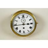 A brass cased ship's bulkhead clock with white face, Roman numerals and secondary seconds dial, 8"