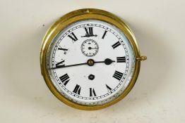 A brass cased ship's bulkhead clock with white face, Roman numerals and secondary seconds dial, 8"