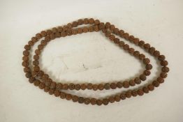 A long string of nut kernel prayer beads, 68" long