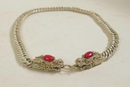 A Chinese white metal necklace with dragon head decoration to ends, 24" long