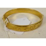 An engraved 9ct bangle with metal core, gross 17 grams, 2½" diameter