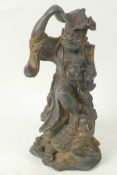 A Chinese bronze figure of a traveller with lotus leaf hat and chain of luck coins, standing with