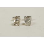 A pair of 14ct white gold diamond stud earrings, 64 points