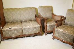 A 1930s walnut bergere suite comprising a two seat settee and two matching armchairs
