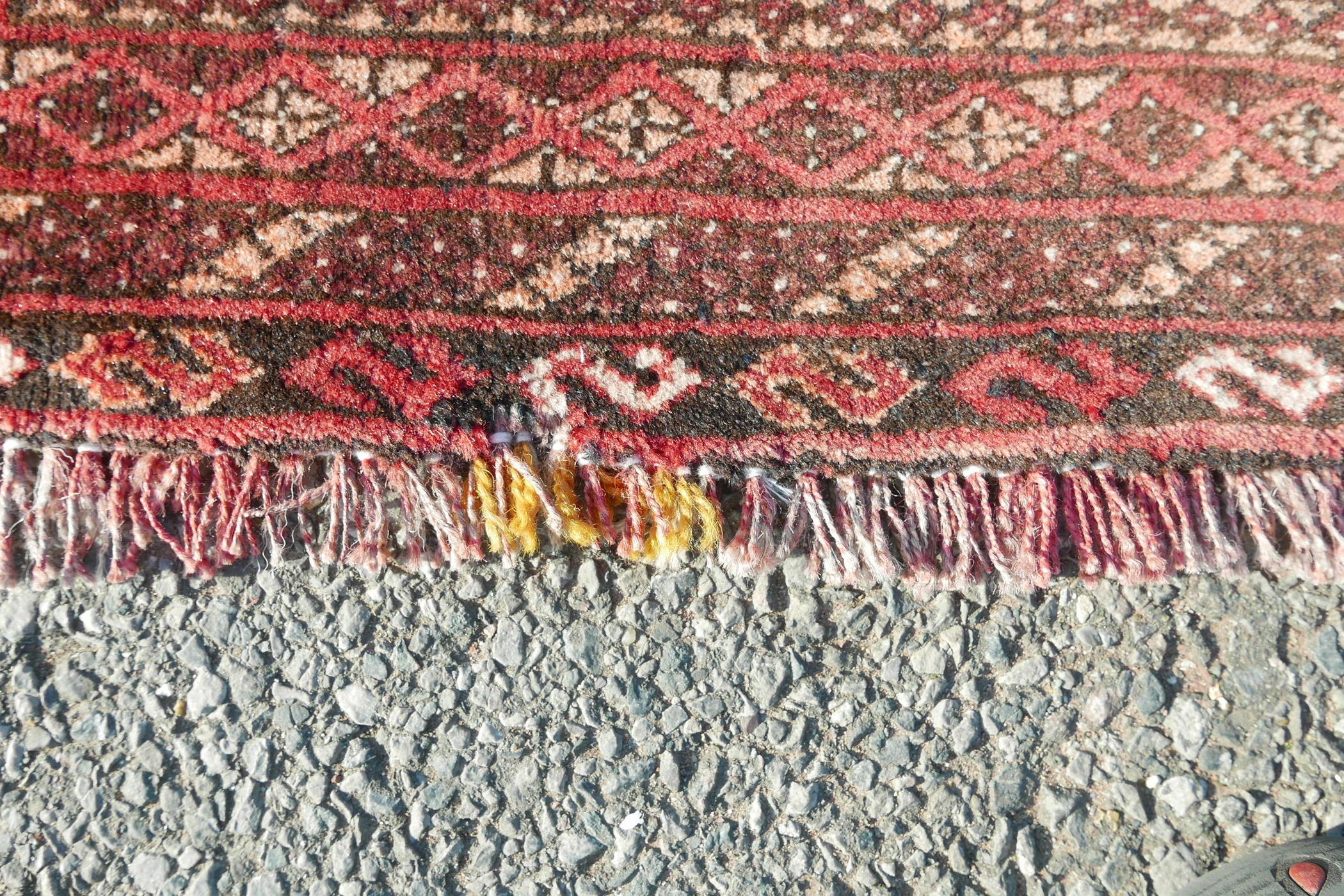 A washed red ground Turkmen carpet with a Bokhara design, repairs, 56" x 90" - Image 3 of 6