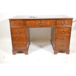 A mahogany pedestal desk with a tooled inset top, hidden keyboard drawer/slide, drawers and a