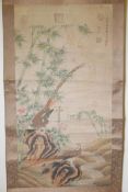 A Chinese watercolour scroll depicting Asiatic pheasants in a landscape with bamboo and flowers, 26"